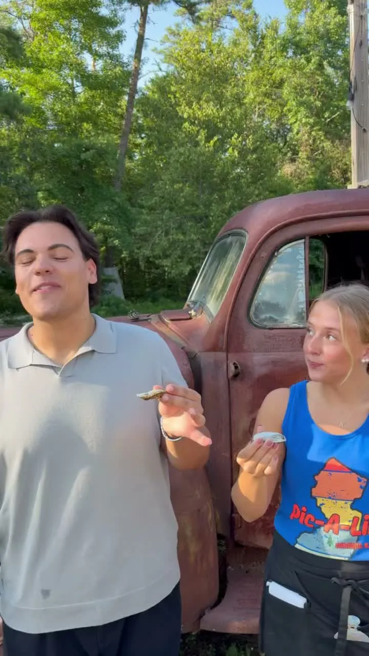 Two of the Pic-A-Lilli crew tasting oysters beside the old truck